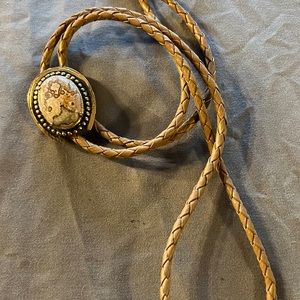 Tan bolo tie with horseshoe shape and colorful stone